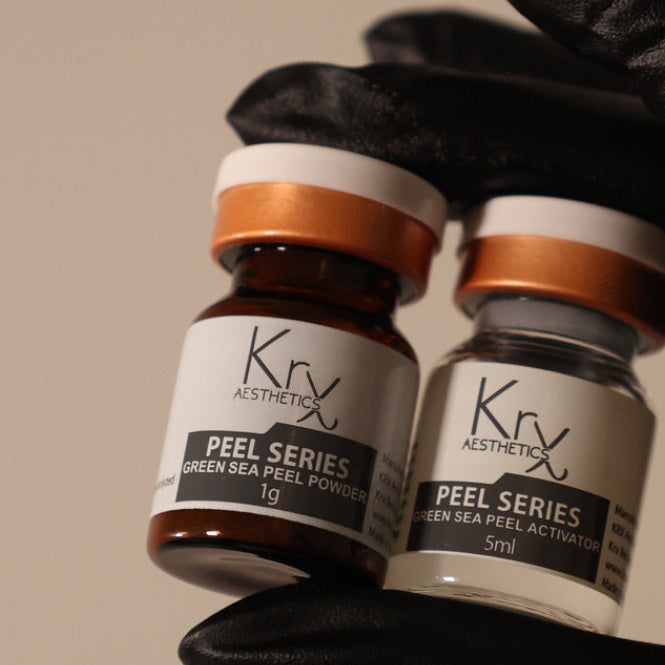 Two bottles of Krx Aesthetics Peel Series with a gloved hand holding them.